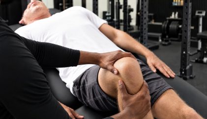 Duane giving a client an assisted knee stretch at Brewster’s studio