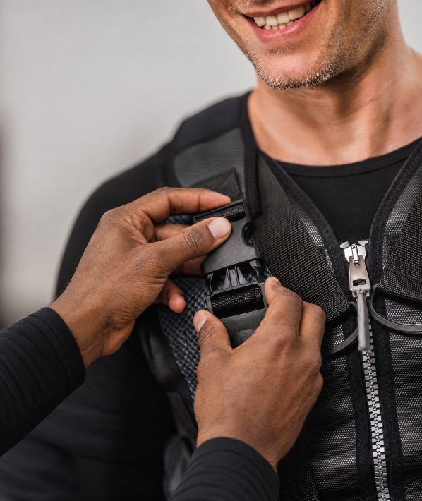 Duane fastening a client's EMS training vest