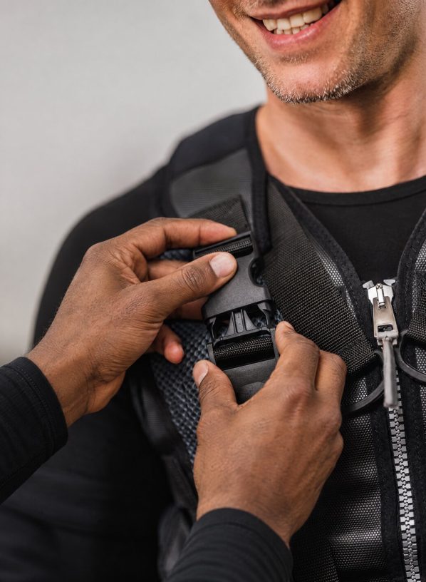 Duane fastening a client's EMS training vest