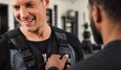 Duane adjusting a smiling client's EMS vest