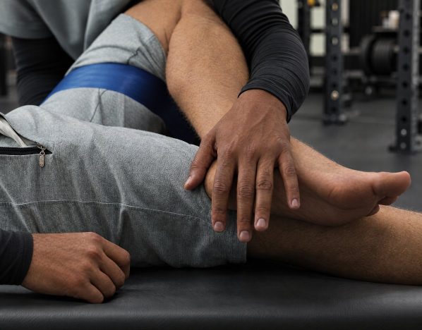 Duane assisting a client’s leg stretch on the treatment table